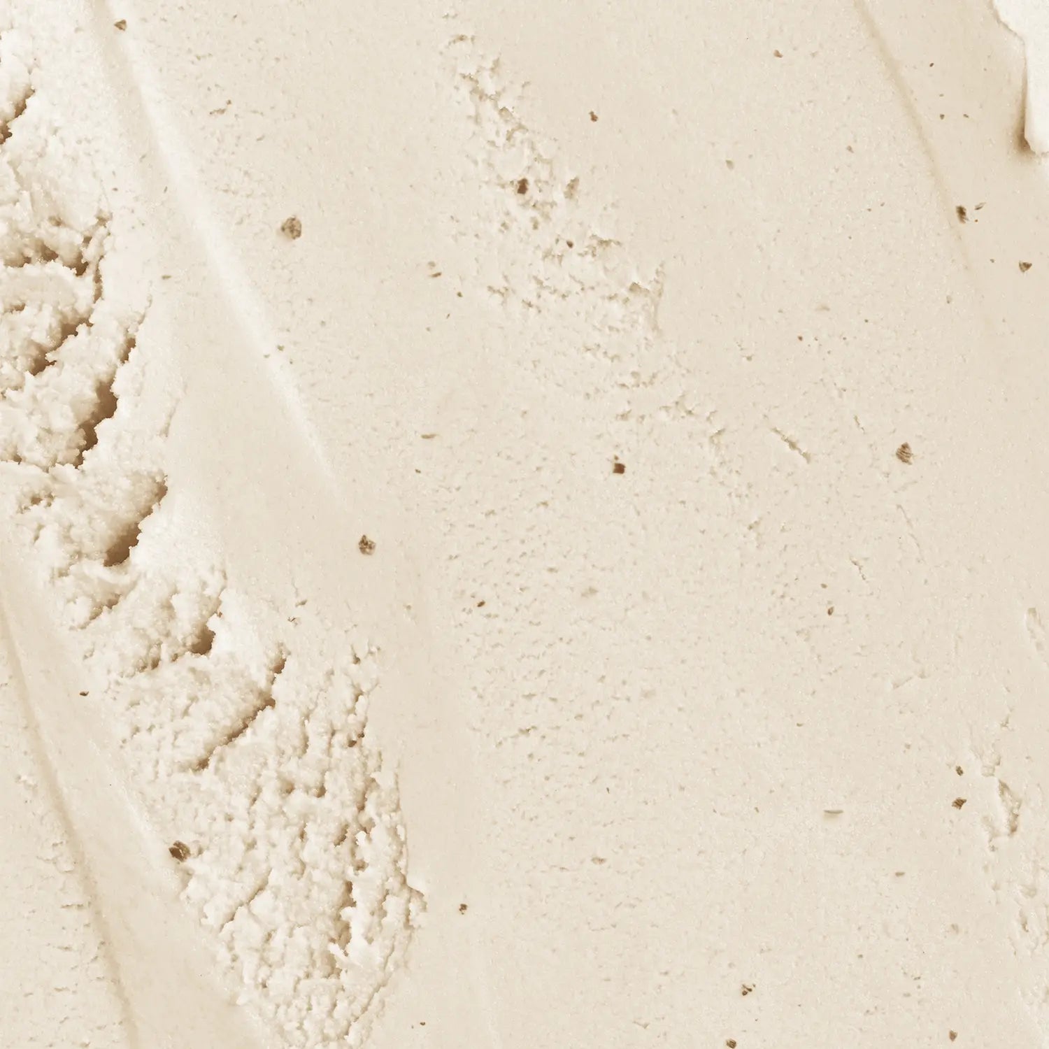 A cream-colored makeup soothing face scrub swatch with a textured surface of Daily Dose a cosmetic vegan Italian brand