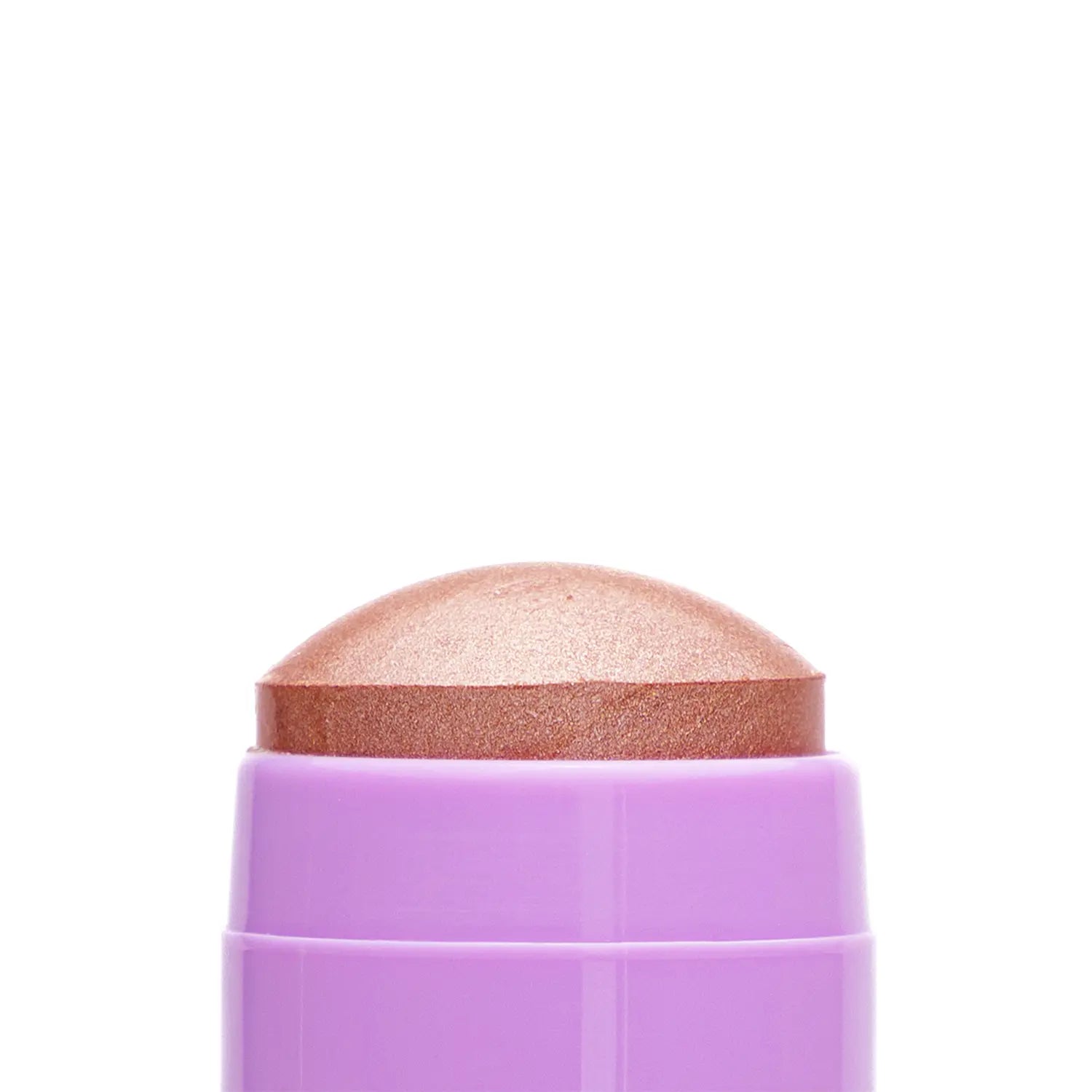 Close-up of a cosmetic Italian vegan highlighter stick named Delulu bronze-colored makeup swatch with a textured surface.